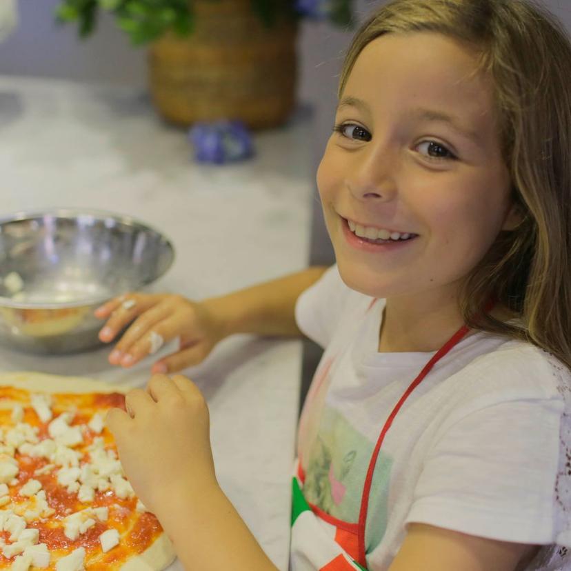 Pizza Masterclass in Rome A young girl making her own pizza during the Pizza Masterclass