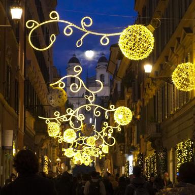 Rome at Christmas street lights and festive evening atmosphere Rome at Christmas with festive lights illuminating a historic street at night
